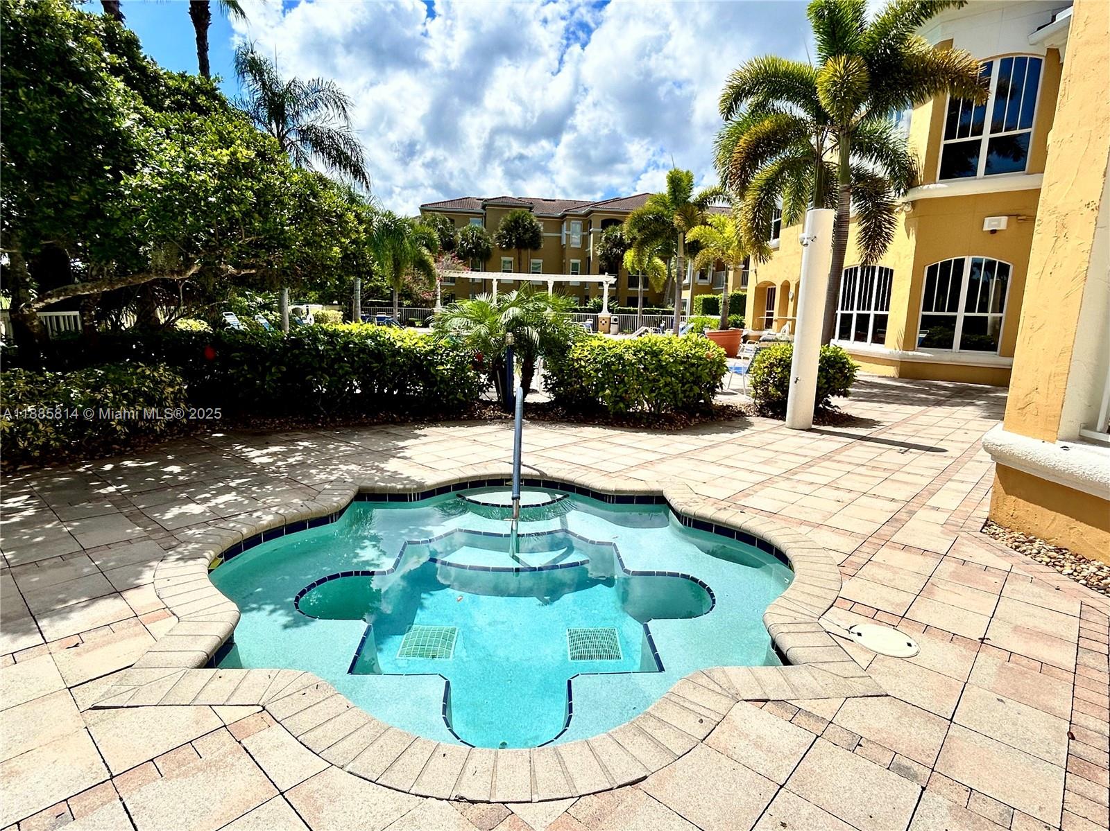 5080 Fairways Circle, Unit 307 Vero Beach, FL 32967 - Photo 20 of 27 a swimming pool with potted plants and large trees