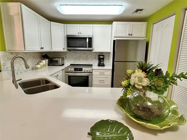 a kitchen with a sink a stove and a refrigerator