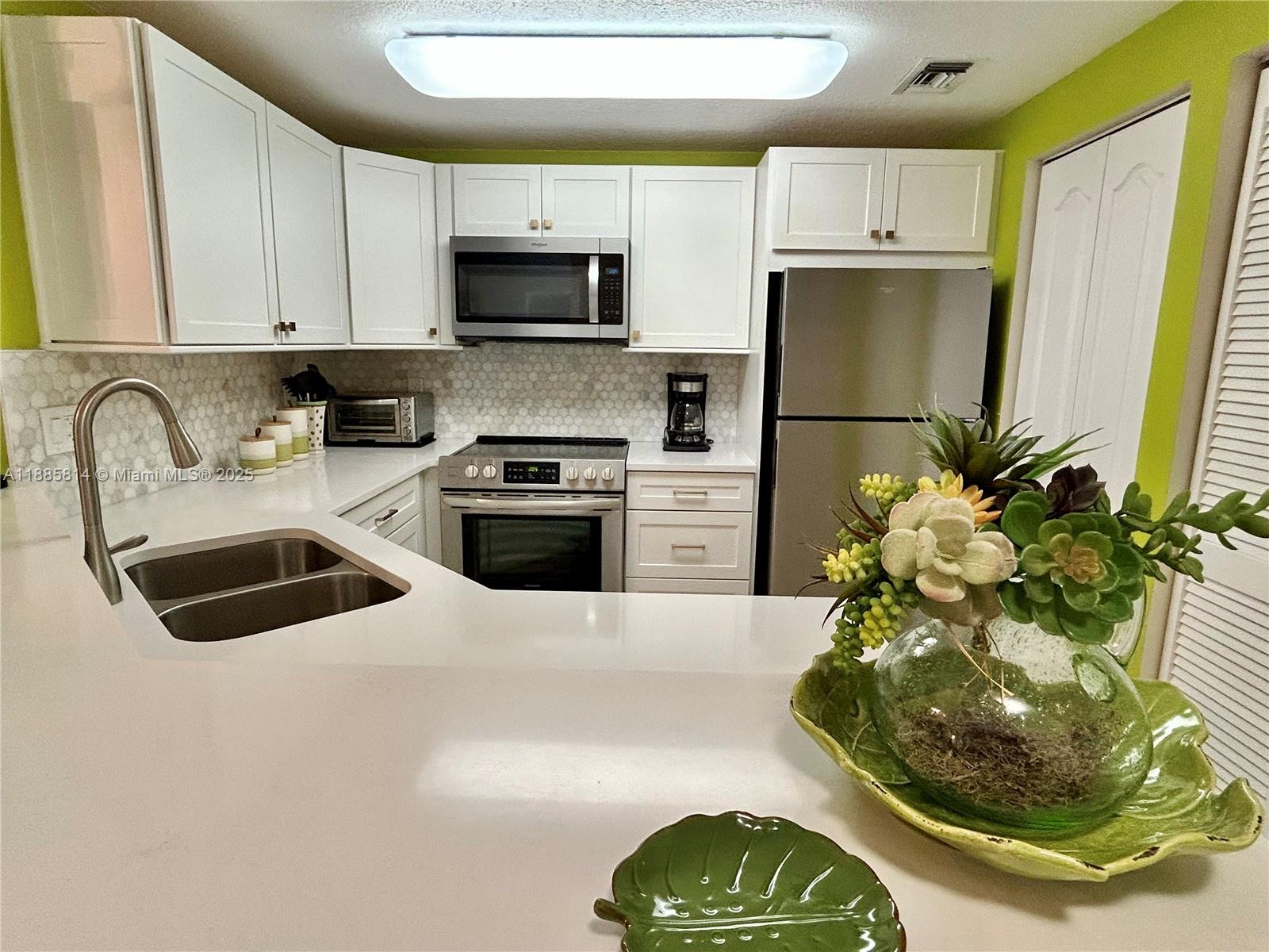 5080 Fairways Circle, Unit 307 Vero Beach, FL 32967 - Photo 3 of 27 a kitchen with a sink a stove and a refrigerator