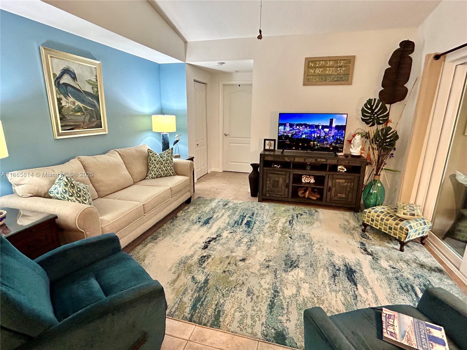 5080 Fairways Circle, Unit 307 Vero Beach, FL 32967 - Photo 7 of 27 a living room with furniture and a flat screen tv