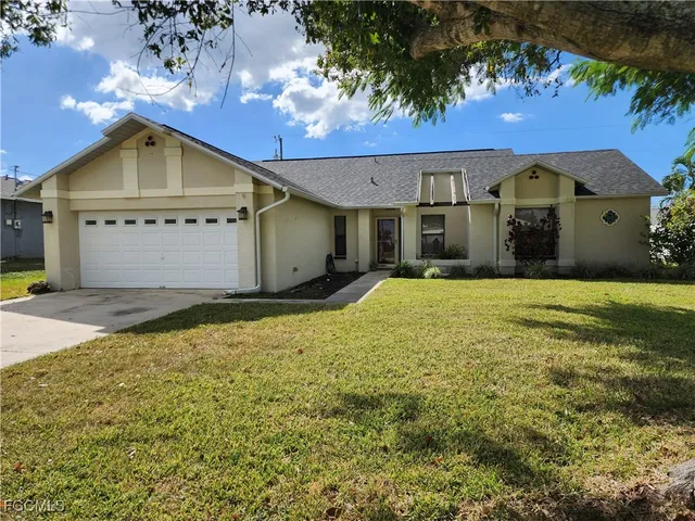 a front view of house with yard and garage