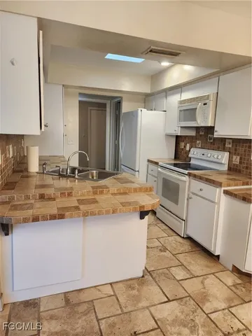 a kitchen with kitchen island granite countertop a sink stove and cabinets
