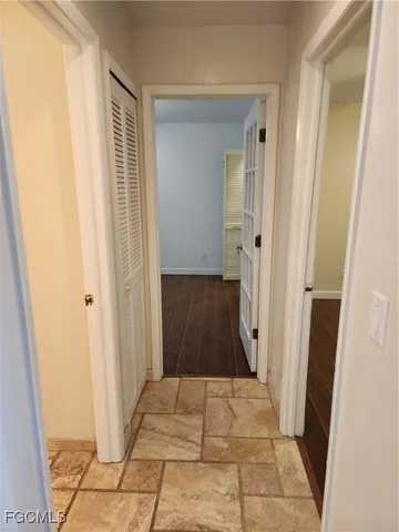 a view of a hallway with wooden floor and a door