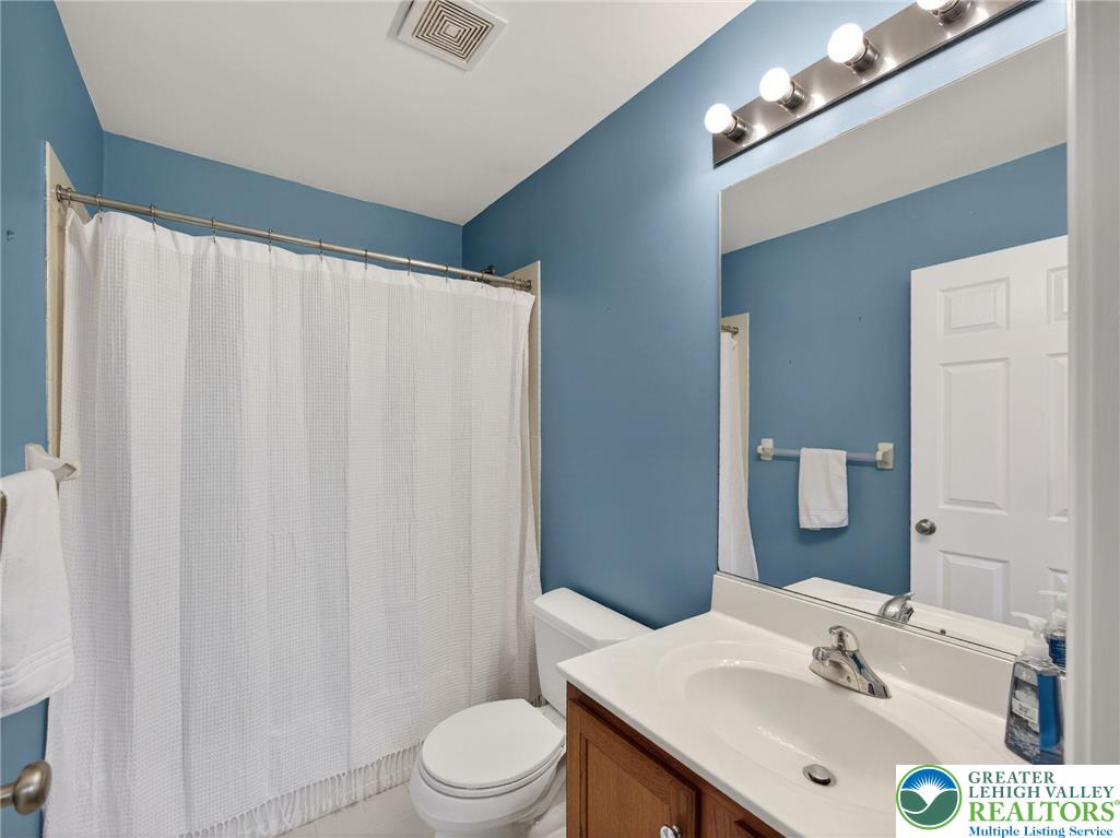 4312 Creek Road Allentown, PA 18104 - Photo 46 of 67 a bathroom with a sink a toilet a mirror and shower curtain