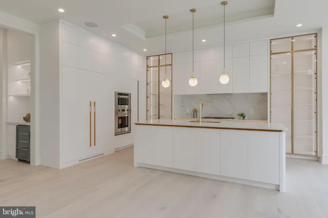 a large white kitchen with a refrigerator a sink and a oven