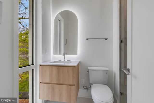 a bathroom with a toilet a sink and a window