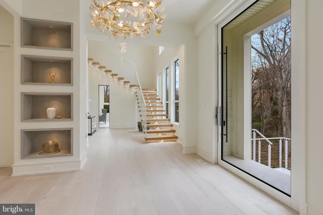 a view of a hallway with wooden floor and a front door