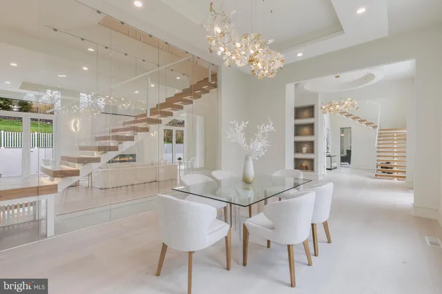 a room with stainless steel appliances kitchen island granite countertop furniture and a chandelier