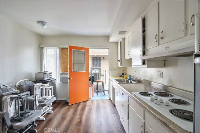 a kitchen with a stove a refrigerator and wooden floor