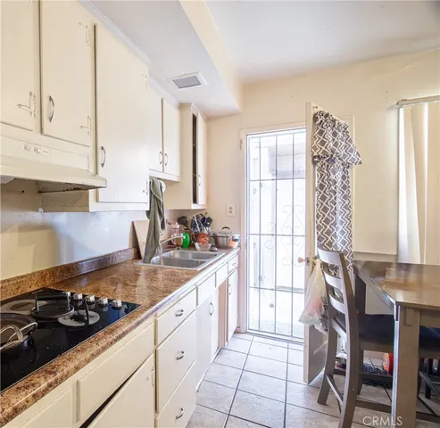 a kitchen with a stove a window and cabinets