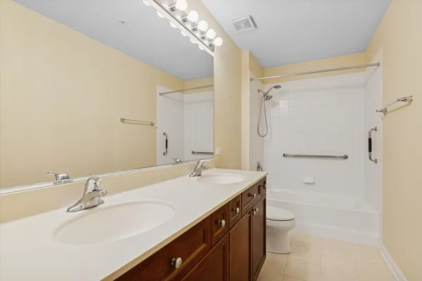 a bathroom with a sink a toilet a mirror and shower