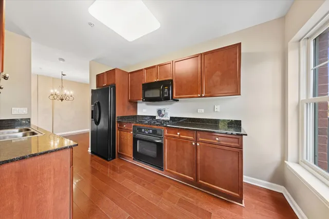 a kitchen with stainless steel appliances granite countertop a refrigerator stove top oven and sink