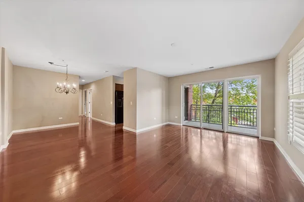 a view of a big room with wooden floor and windows