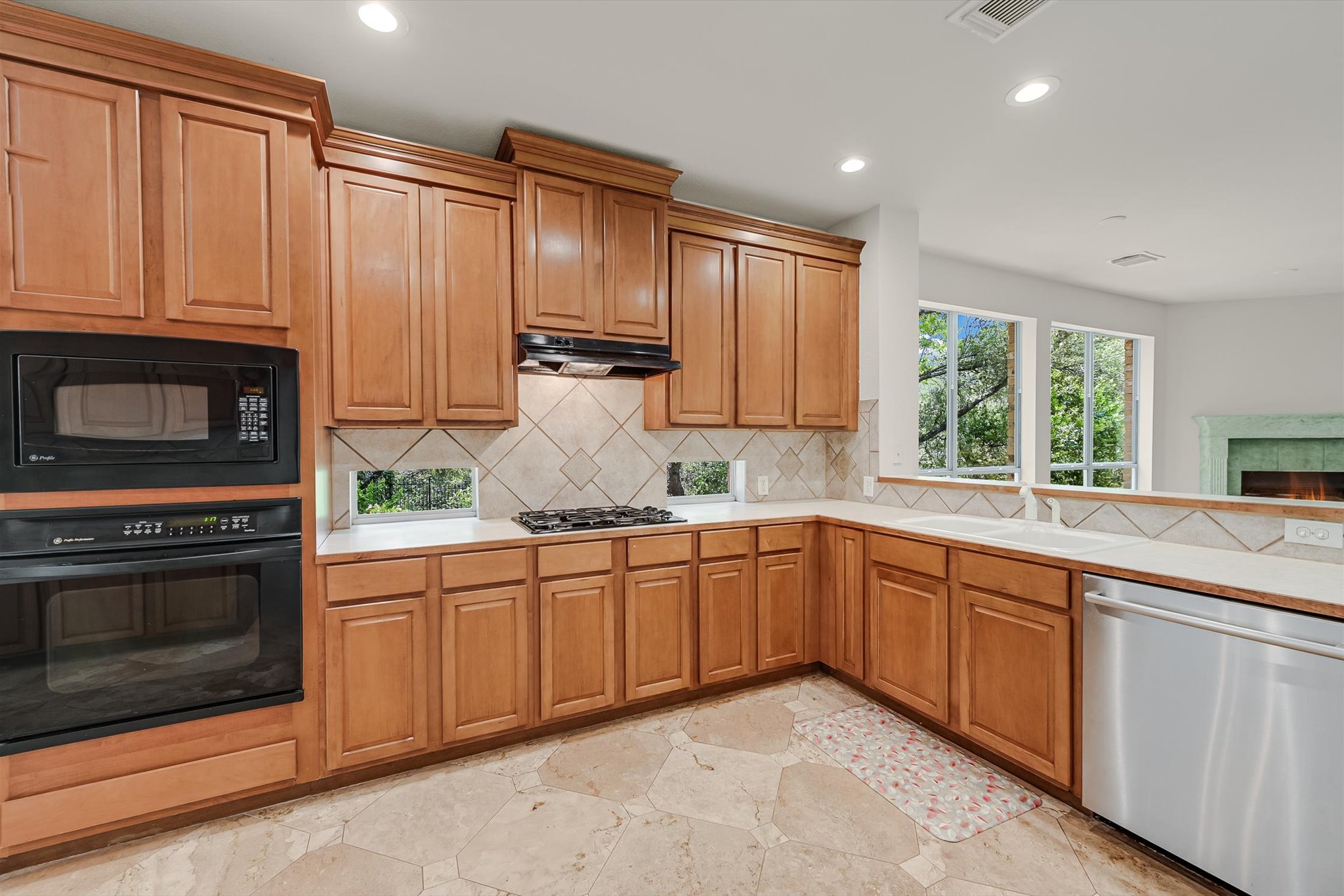 2849 Grimes Ranch Road Austin, TX 78732 - Photo 11 of 31 A well-appointed kitchen features natural wood cabinetry and a view of the surrounding trees.