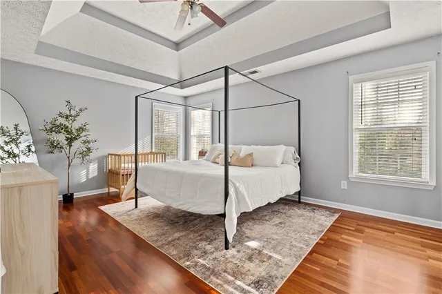 a bed sitting in a bedroom next to a window with potted plants