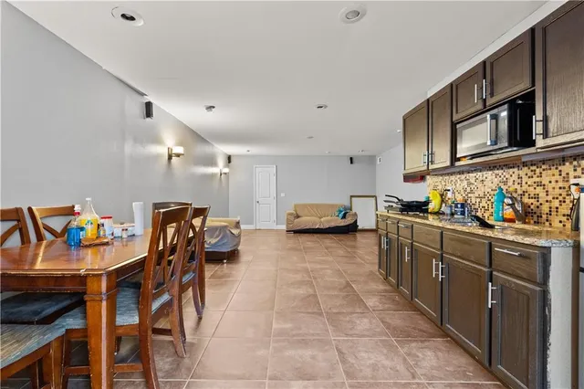 a kitchen with stainless steel appliances kitchen island granite countertop a table and chairs in it