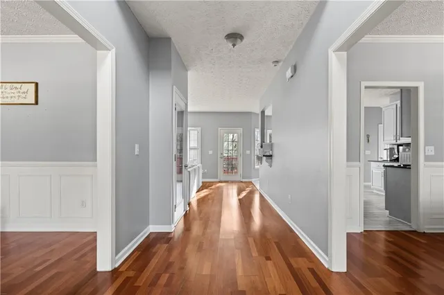 a view of a hallway with wooden floor and staircase