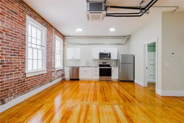 a large kitchen with stainless steel appliances granite countertop a refrigerator and microwave