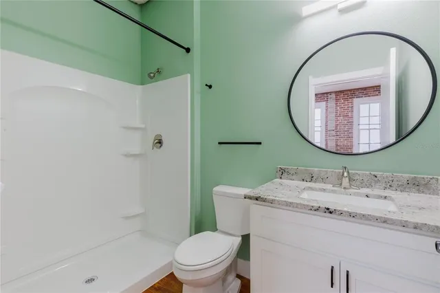 a bathroom with a granite countertop sink mirror vanity and toilet