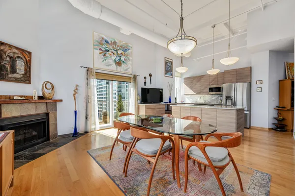 a dining room with furniture a fireplace and wooden floor