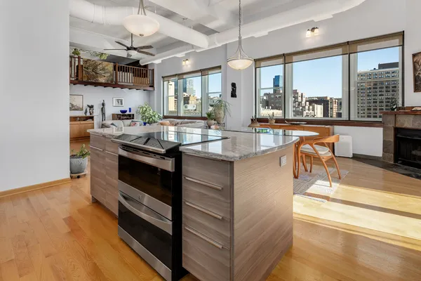a kitchen with stainless steel appliances granite countertop a sink a stove and a wooden floors
