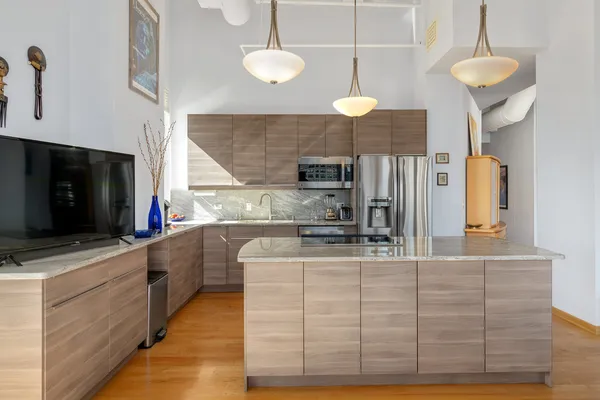 a kitchen with kitchen island granite countertop a sink a counter space appliances and cabinets