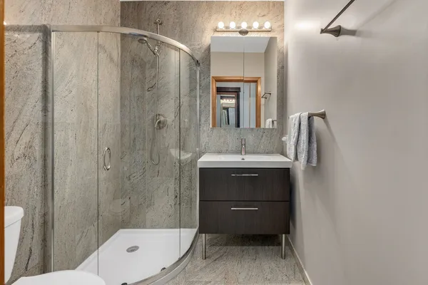 a bathroom with a sink a toilet and shower