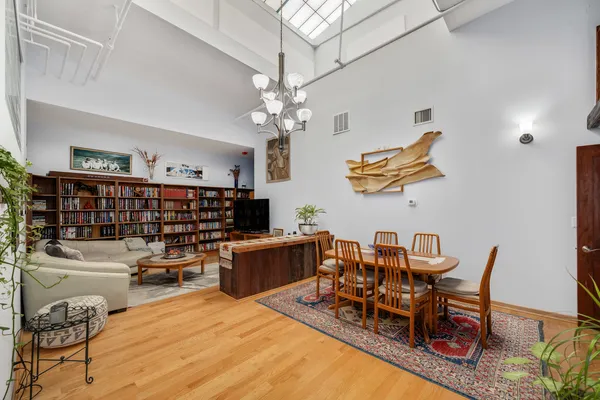 a living room with furniture kitchen view and a chandelier