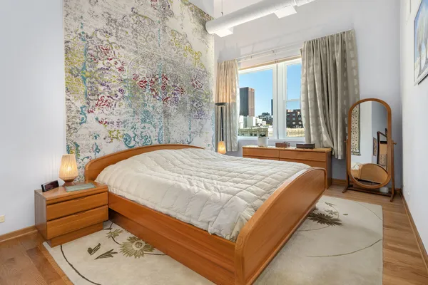 a bedroom with a bed and a mirror on dresser