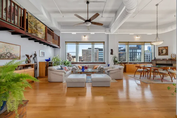 a living room with fireplace furniture and a large window