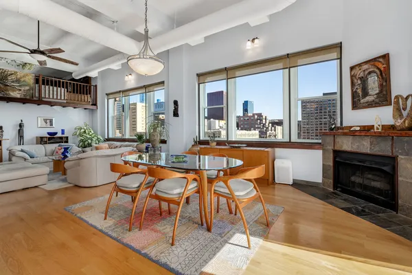 a dining room with furniture a fireplace and wooden floor