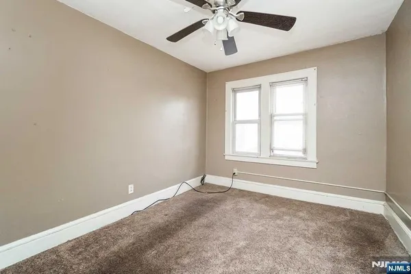 an empty room with a window and a fan