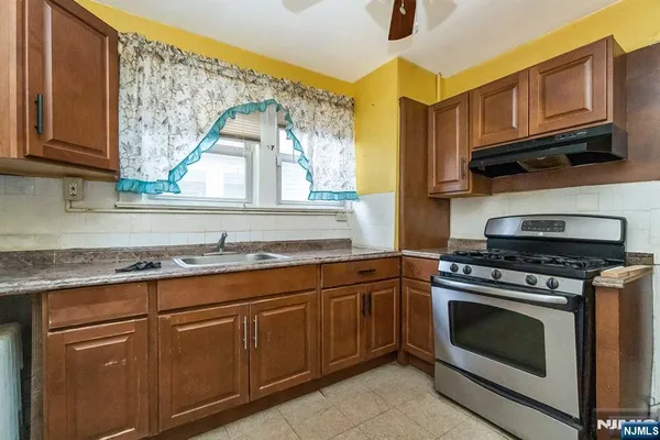 a kitchen with granite countertop a stove top oven microwave and cabinets