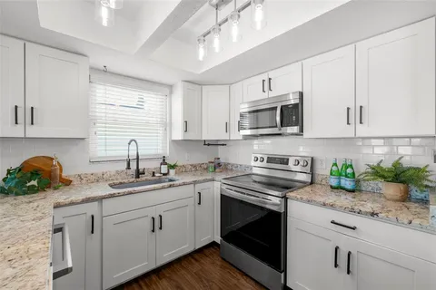 a kitchen with appliances a sink and cabinets