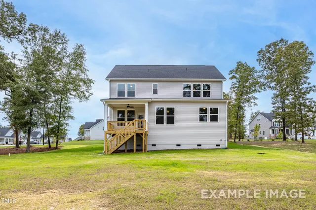 a front view of house with yard and trees in the background