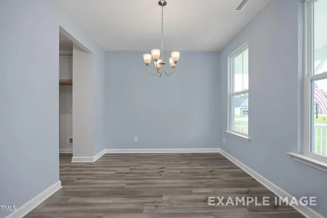 a view of a room with wooden floor and window
