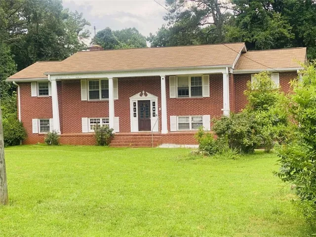a front view of a house with yard and green space