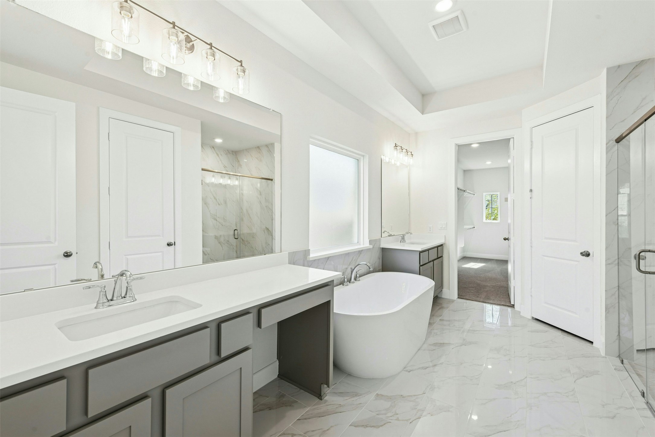 1520 Rodeo Ridge Drive Georgetown, TX 78628 - Photo 9 of 29 Bathroom featuring two vanities, a marble finish shower, light marble finish floors, a freestanding tub, and recessed lighting