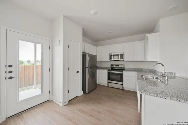 a kitchen with granite countertop a refrigerator and a sink