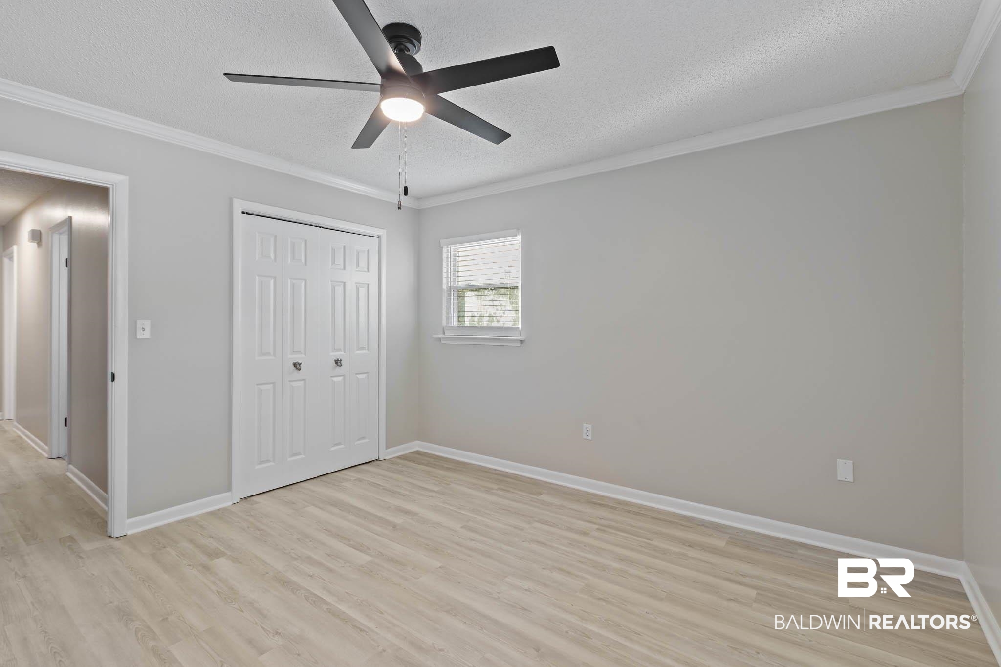 608 Southern Way Daphne, AL 36527 - Photo 23 of 35 Unfurnished bedroom featuring crown molding, a textured ceiling, light wood-type flooring, a closet, and ceiling fan