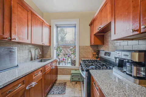 a kitchen with stainless steel appliances granite countertop a stove a sink and a microwave