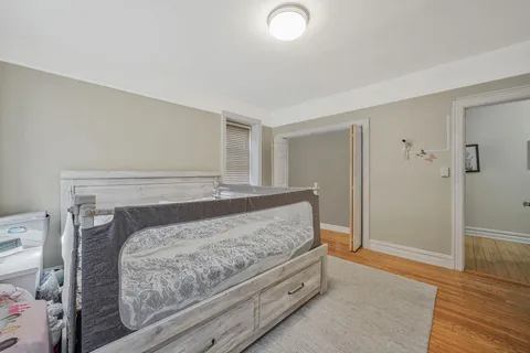 a bedroom with a bed and wooden floor