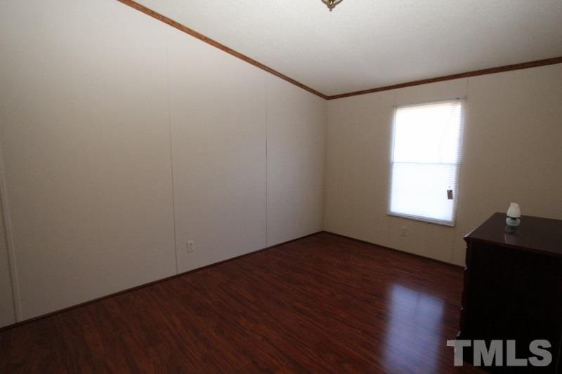 350 Big Pine Road Clayton, NC 27520 - Photo 12 of 20 a view of an empty room with wooden floor and a window