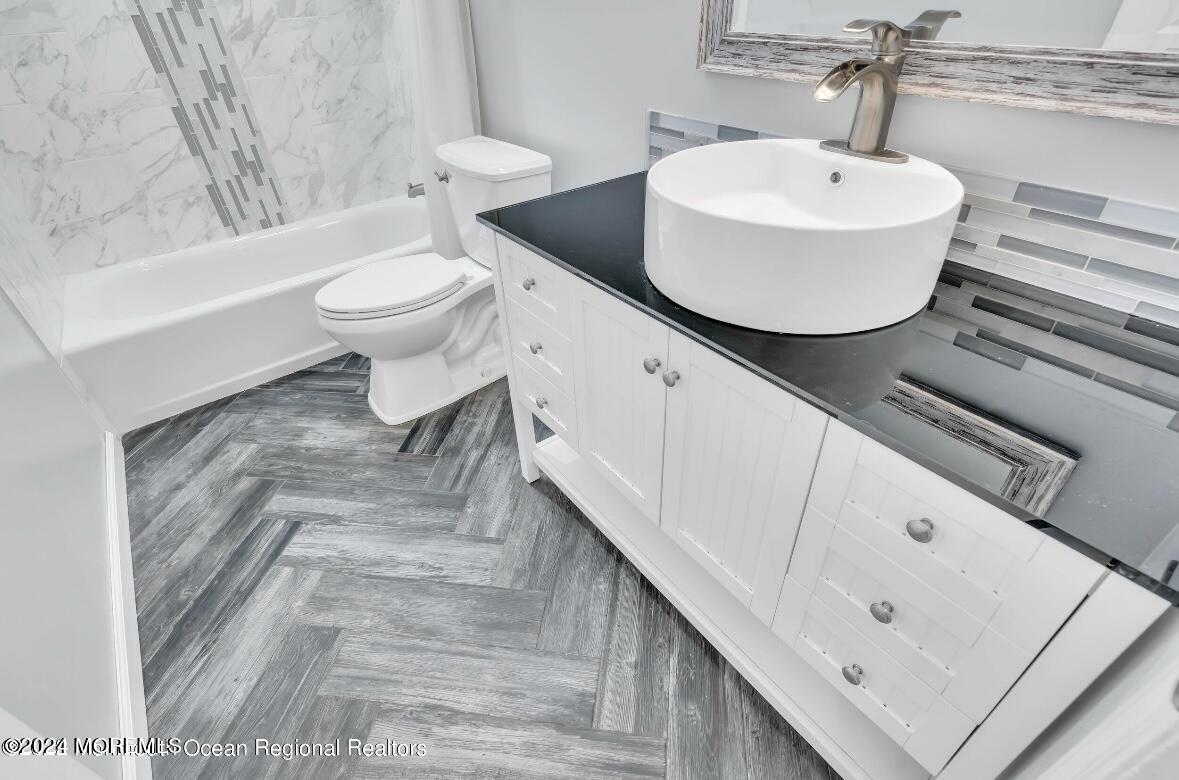 1002 Sawmill Road Brick, NJ 08724 - Photo 17 of 27 a bathroom with a sink a toilet and bathtub