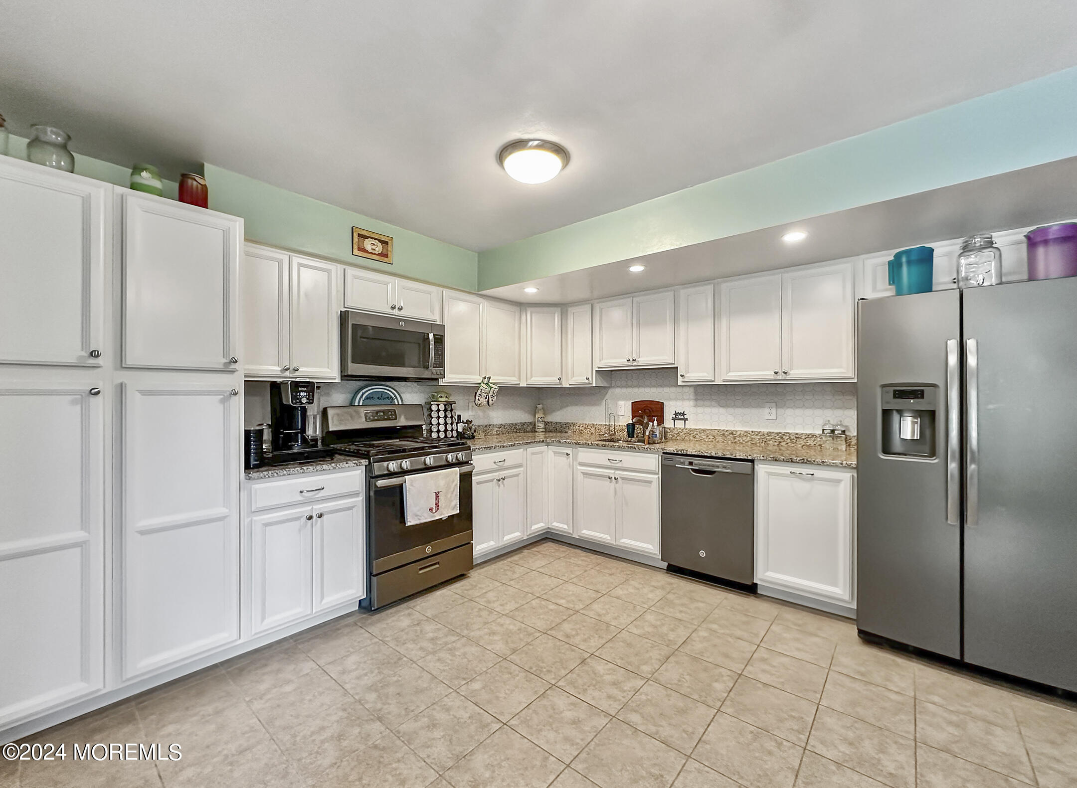 1002 Sawmill Road Brick, NJ 08724 - Photo 8 of 27 a kitchen with granite countertop a refrigerator sink and white cabinets