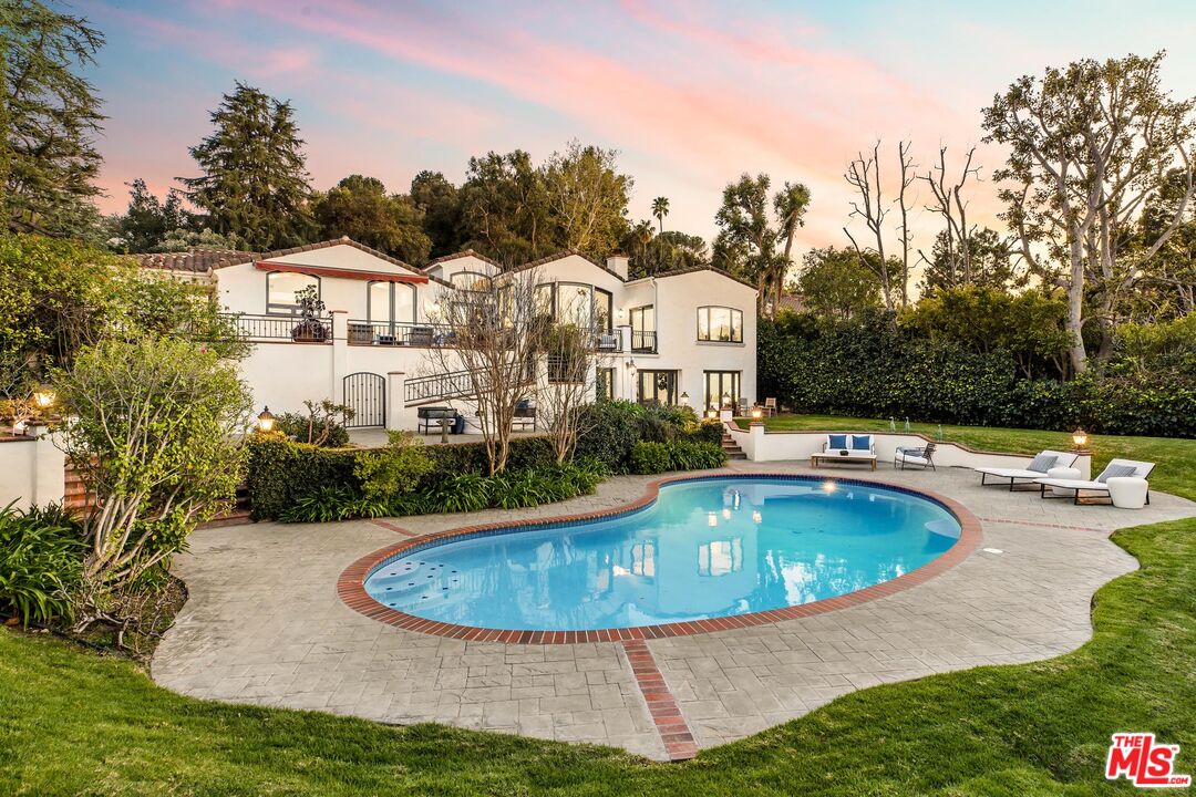 a view of a house with swimming pool and sitting area