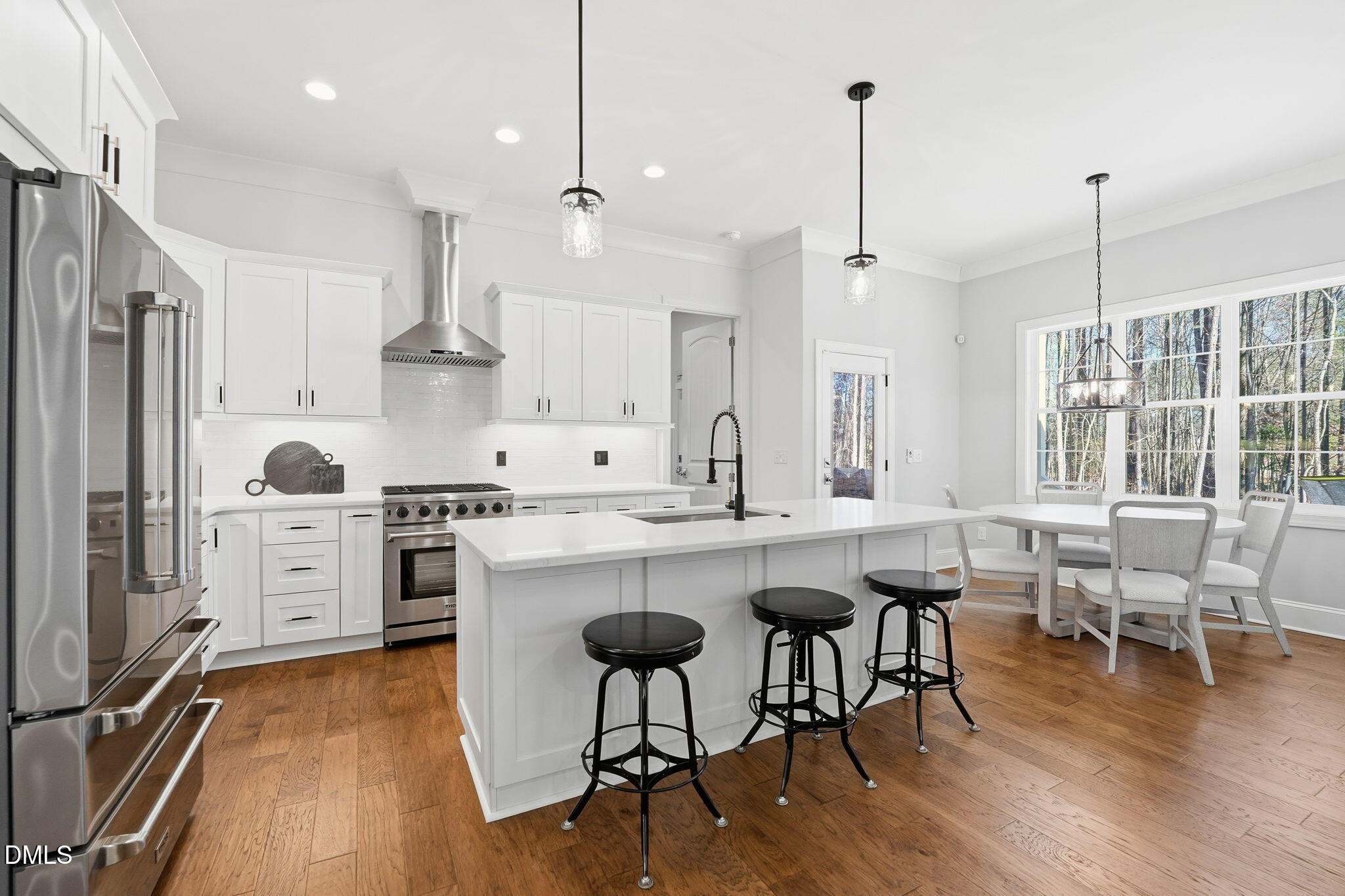 100 North Ridge View Way Franklinton, NC 27525 - Photo 5 of 25 a kitchen with stainless steel appliances granite countertop a stove a sink a refrigerator and a dining table with wooden floor