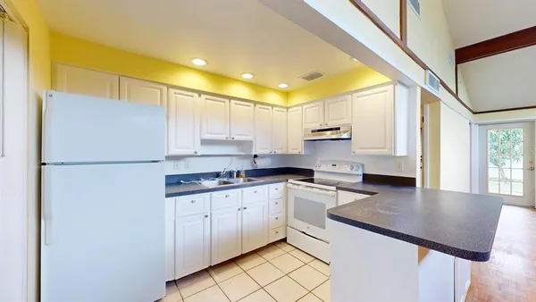 a kitchen with stainless steel appliances granite countertop a sink refrigerator and cabinets