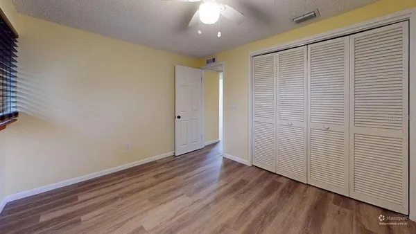 a view of an empty room with wooden floor