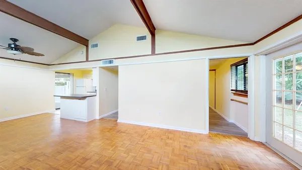 a view of a big room with wooden floor and windows